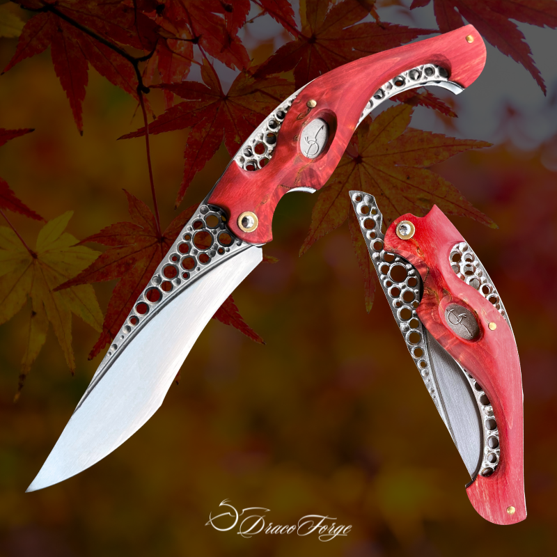 Neptune 52 couteau pliant artisanal rouge ajourages circulaires inox bouleau madré Dracoforge Neptune 52 couteau pliant artisanal rouge ajourages circulaires inox bouleau madré Dracoforge