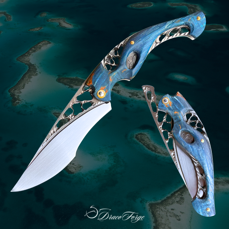 Neptune 59 couteau fermant artisanal peuplier bleu ajourages organiques dentelle acier thème océan Dracoforge Neptune 59 couteau fermant artisanal peuplier bleu ajourages organiques dentelle acier thème océan Dracoforge